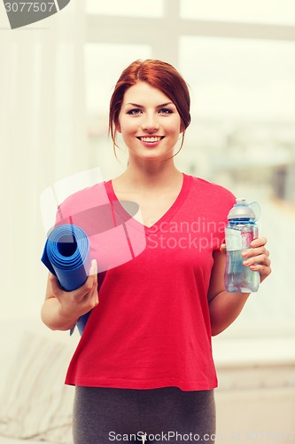 Image of smiling girl with bottle of water after exercising