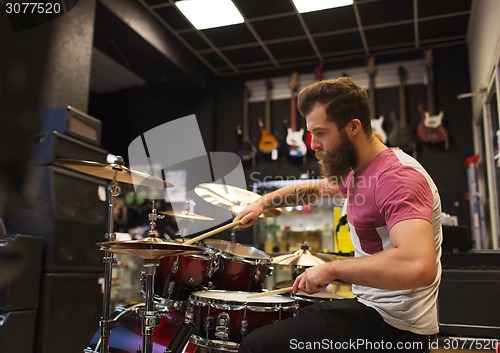 Image of male musician playing cymbals at music store