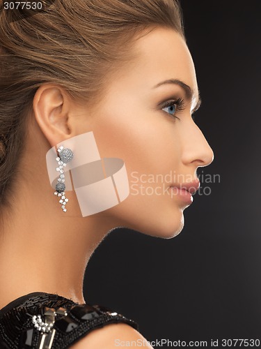 Image of woman wearing shiny diamond earrings