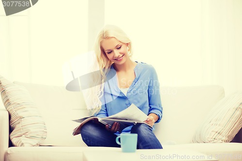 Image of woman sitting on couch and reading magazine