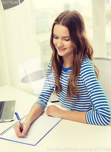 Image of smiling teenage girl laptop computer and notebook