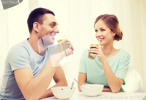 Image of smiling couple having breakfast at home