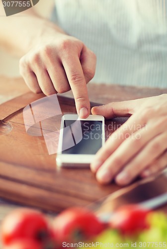 Image of closeup of man pointing finger to smartphone