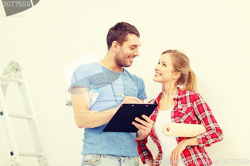 Image of smiling couple with clipboard and wallpaper roll