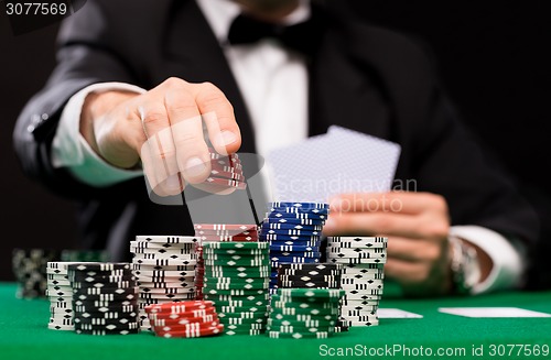 Image of poker player with cards and chips at casino