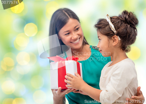 Image of happy mother and daughter with gift box