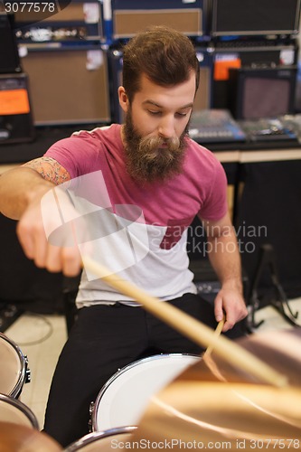 Image of male musician playing cymbals at music store