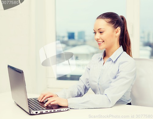 Image of businesswoman with laptop in office