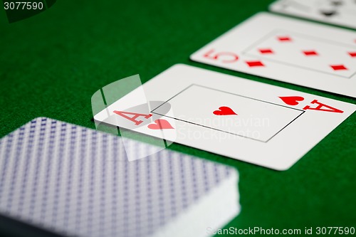 Image of close up of playing cards on green table surface
