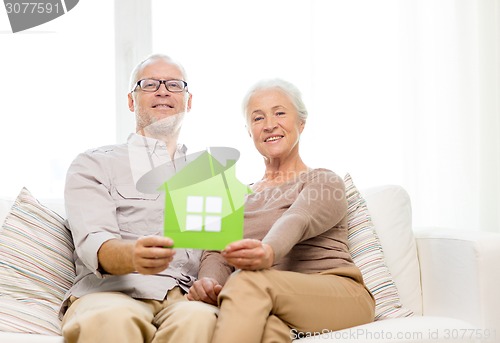 Image of happy senior couple hugging on sofa at home