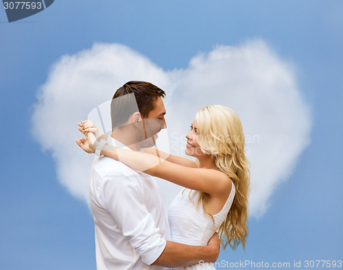 Image of happy couple hugging over heart shaped cloud