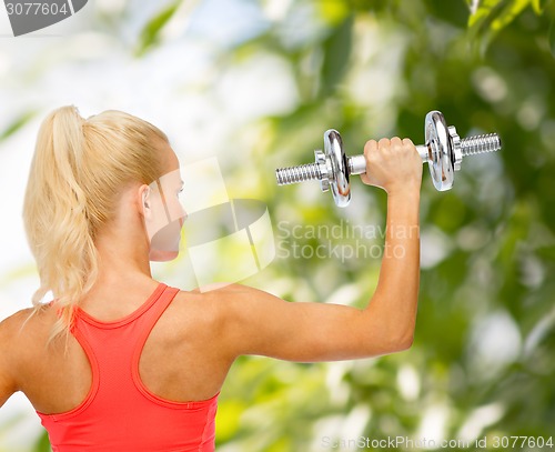 Image of sporty woman with heavy steel dumbbell from back