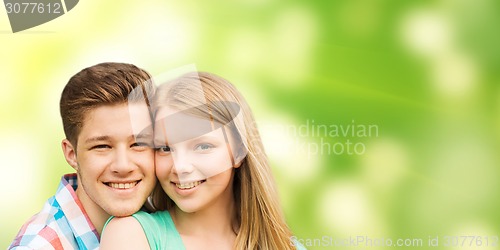 Image of smiling couple hugging over green background