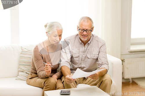 Image of senior couple with papers and calculator at home