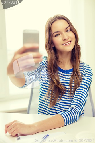 Image of smiling student girl with smartphone and books