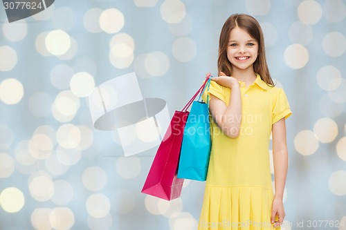 Image of smiling little girl in dress with shopping bags