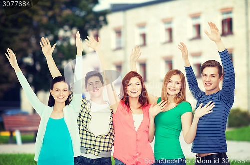 Image of group of smiling students waving hands