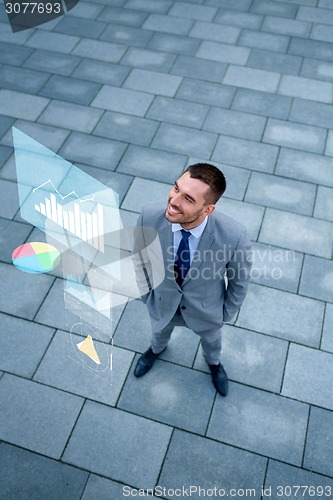 Image of smiling businessman with chart outdoors from top