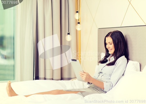 Image of happy businesswoman with tablet pc in hotel room