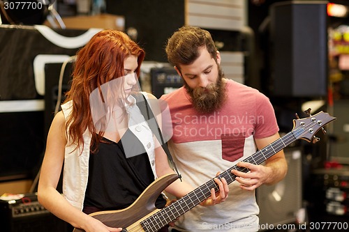 Image of musicians playing bass guitar at music store