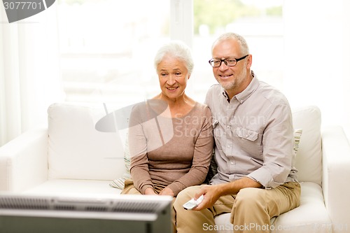 Image of happy senior couple watching tv at home