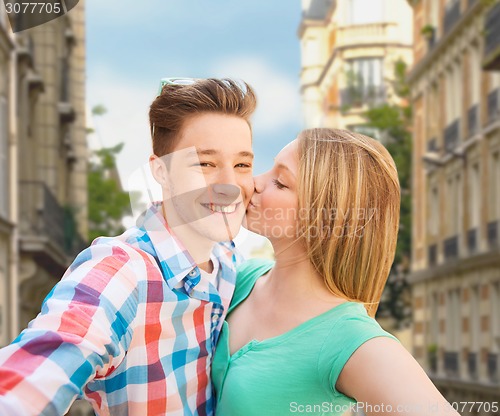 Image of happy couple taking selfie over city background