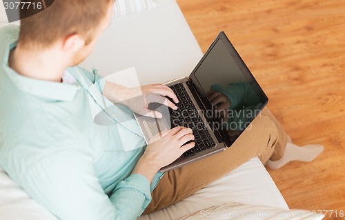 Image of close up of man working with laptop at home