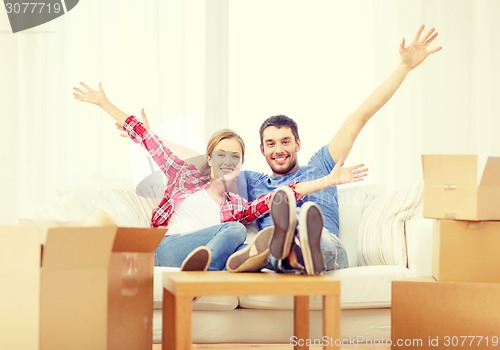 Image of smiling couple relaxing on sofa in new home