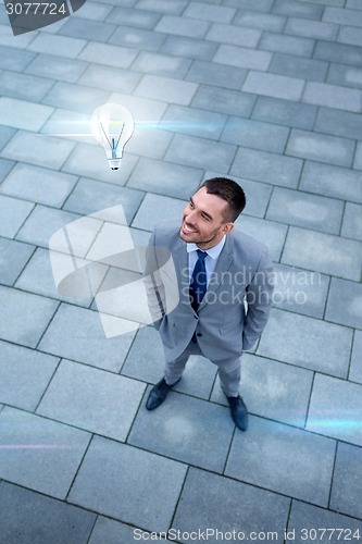 Image of young smiling businessman outdoors from top