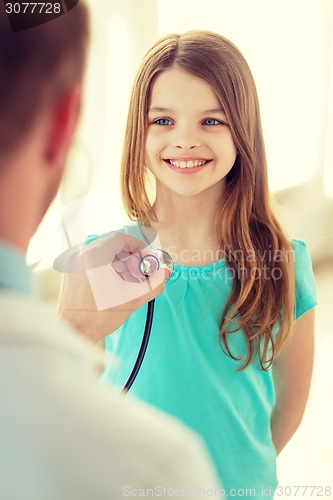 Image of male doctor with stethoscope listening to child