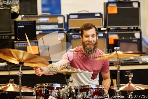 Image of male musician playing cymbals at music store