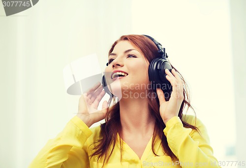 Image of smiling young girl in headphones at home