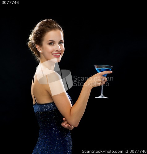 Image of smiling woman holding cocktail