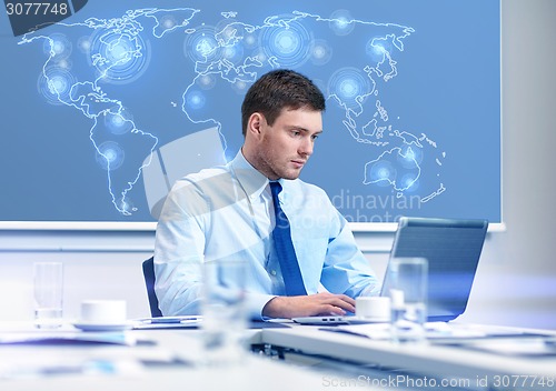 Image of businessman with laptop working in office
