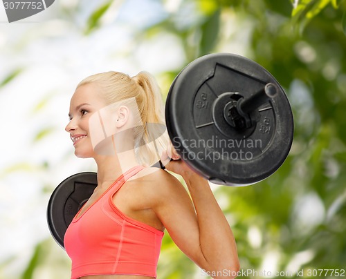 Image of smiling sporty woman exercising with barbell