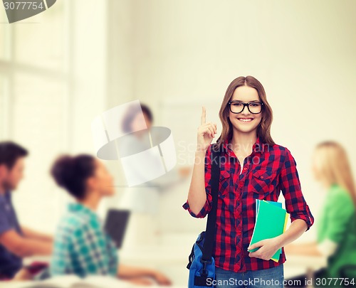 Image of smiling female student with bag and notebooks