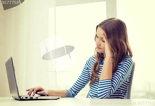 Image of upset teenage gitl with laptop computer at home