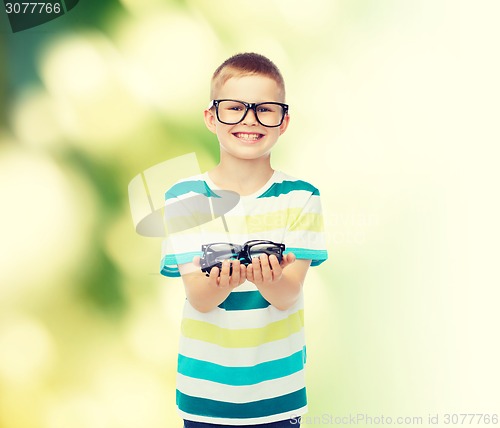 Image of smiling boy in eyeglasses holding spectacles