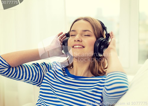 Image of smiling young girl in headphones at home