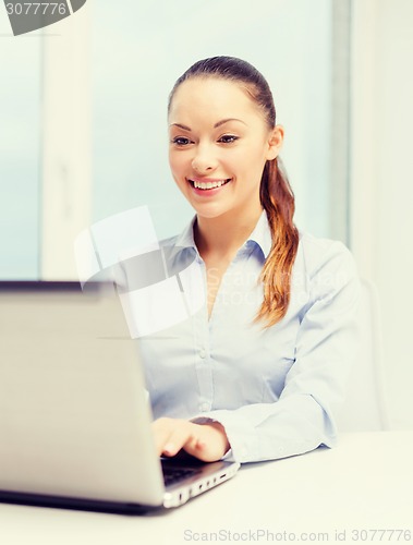 Image of smiling businesswoman with laptop in office