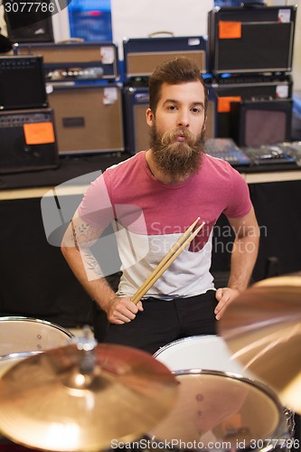 Image of male musician playing cymbals at music store