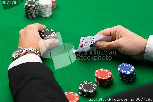 Image of poker player with cards and chips at casino