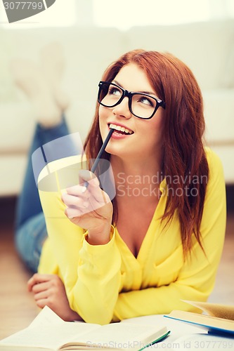 Image of smiling student girl reading books at home