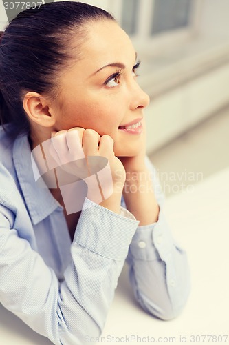 Image of smiling businesswoman dreaming in office