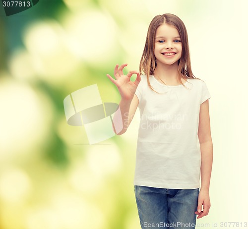 Image of little girl in white t-shirt showing ok gesture