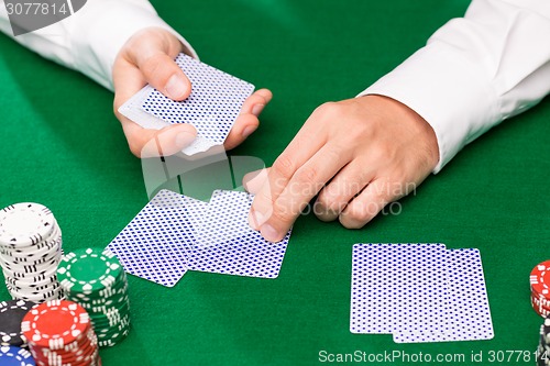 Image of holdem dealer with playing cards and casino chips