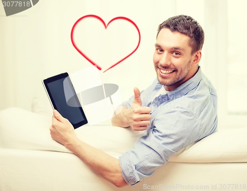 Image of smiling man working with tablet pc at home