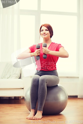 Image of smiling redhead girl exercising with fitness ball