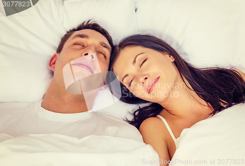 Image of happy couple sleeping in bed