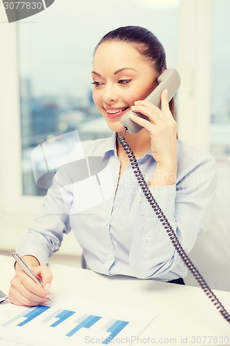 Image of businesswoman with phone, laptop and files